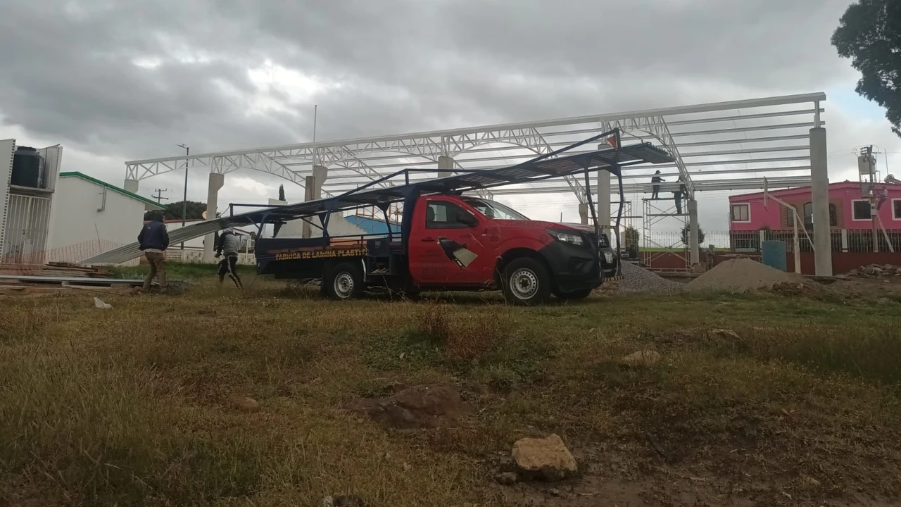 Camioneta roja de reparto en obra, fotografía proporcionada por Fábrica de Láminas Amozoc